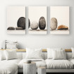 Tríptico minimalista con piedras redondeadas en equilibrio sobre fondo claro. - Cuadrostock